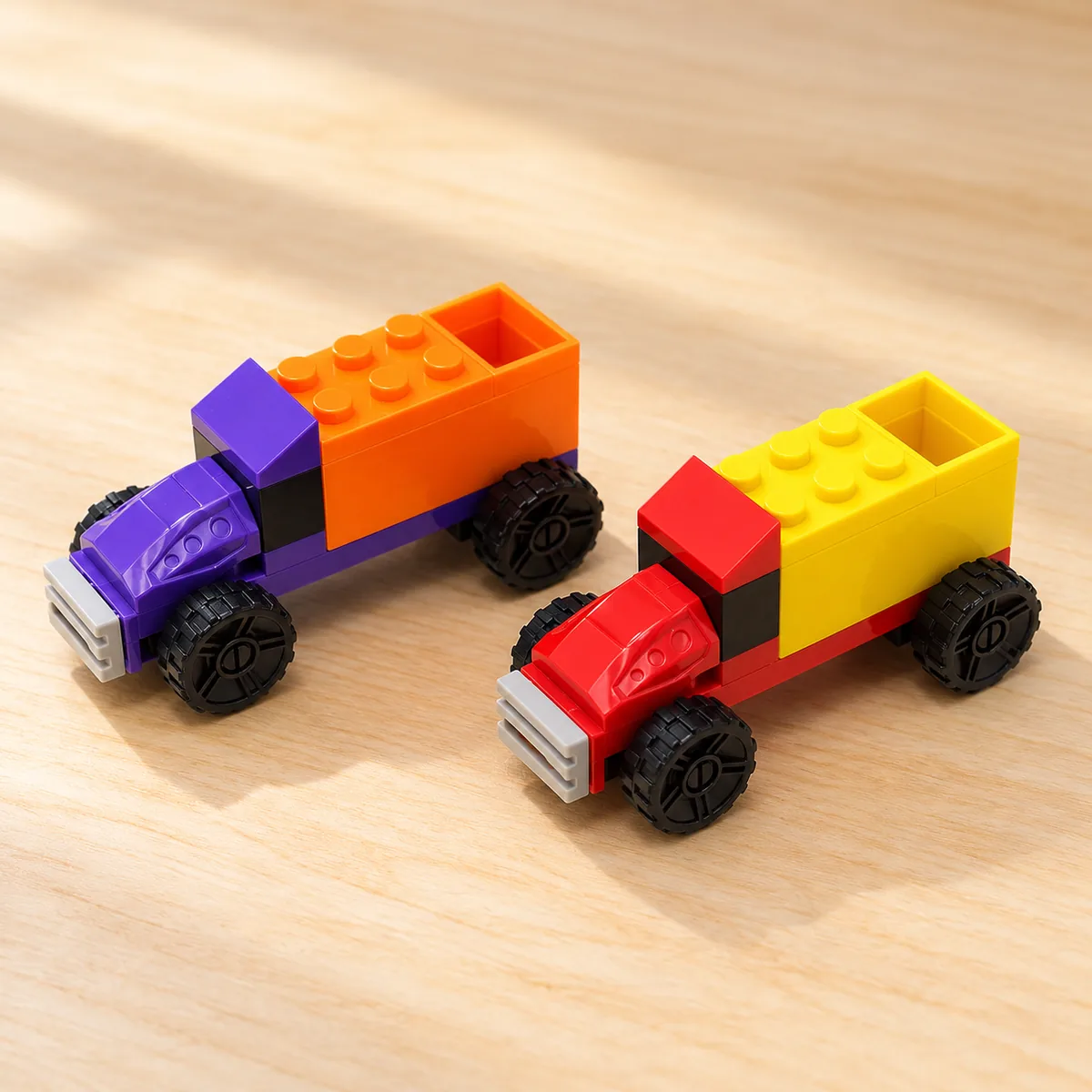 Two Defender Squad tipper trucks in purple-orange and red-yellow
