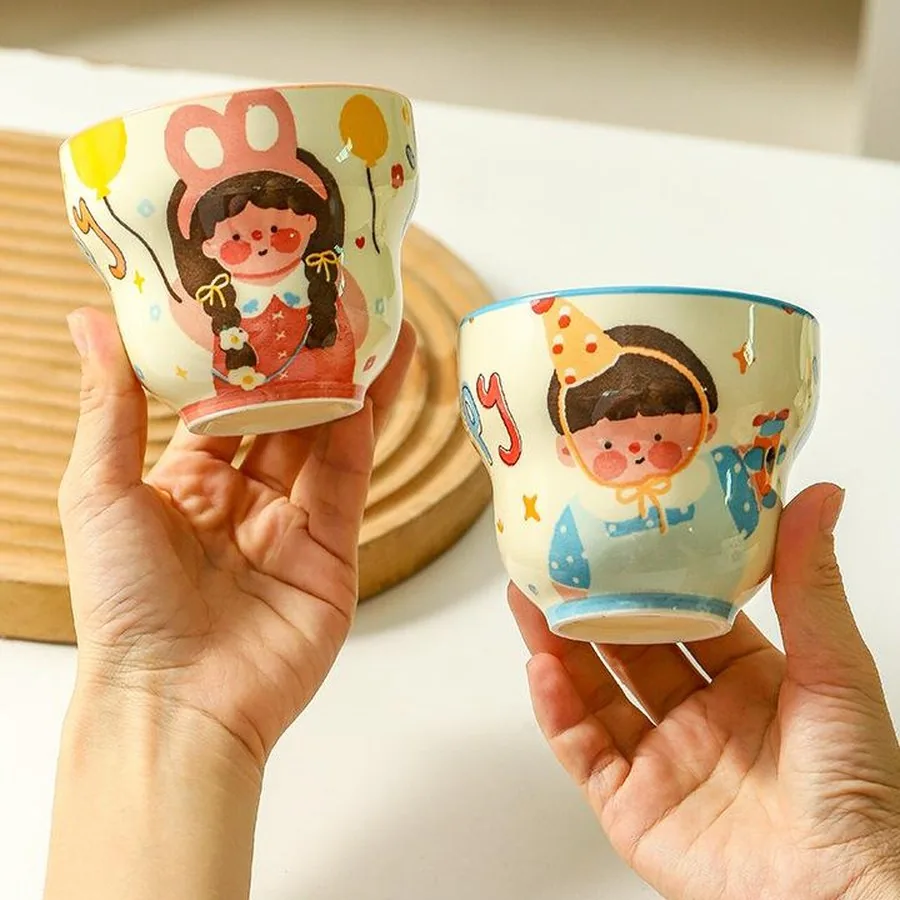 Two ceramic mugs held in hands
