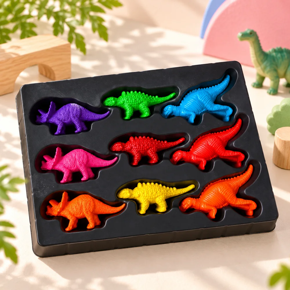 All nine crayons in the tray, top down — triceratops, stegosaurus, brachiosaurus and T-rex shapes in nine colours