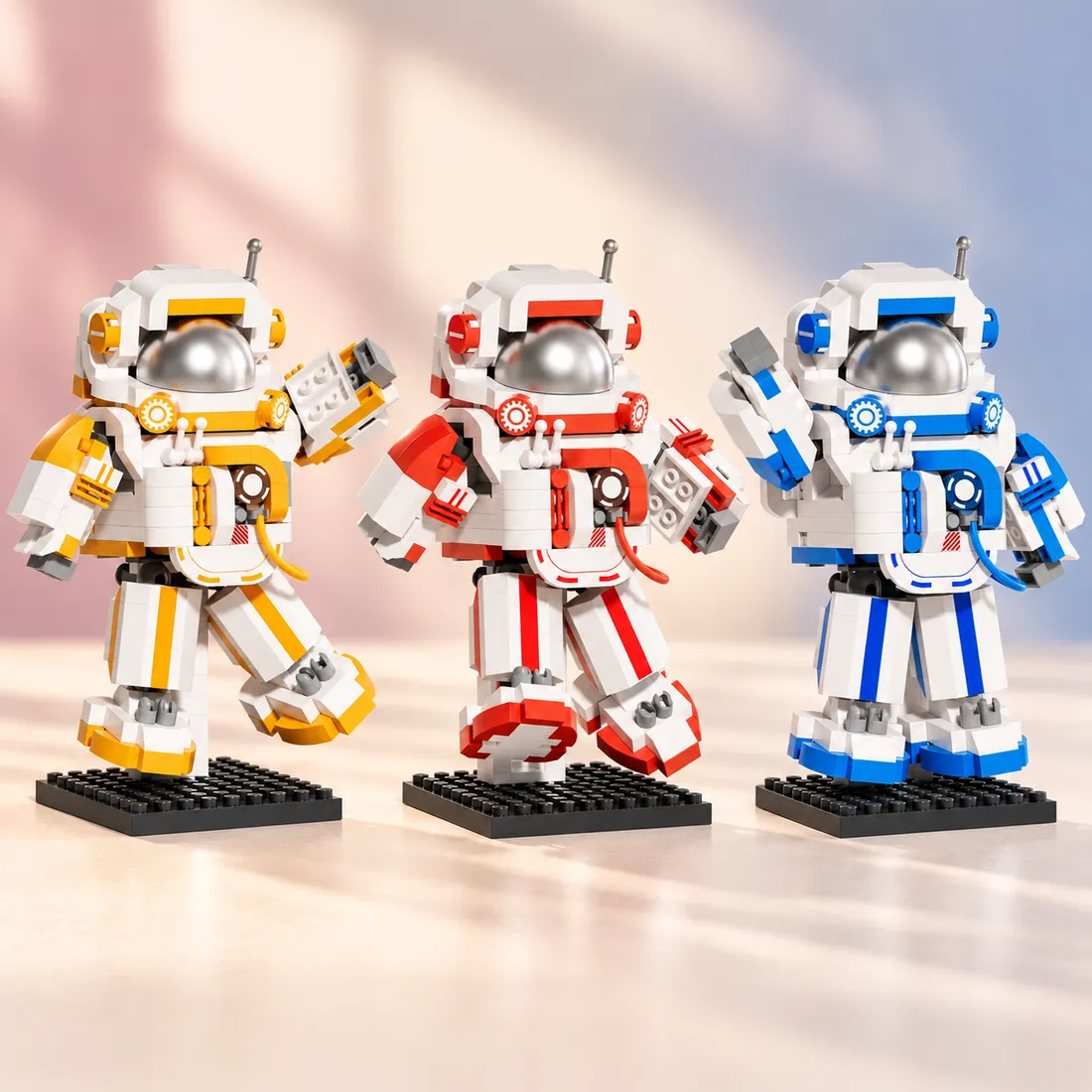 The three astronauts side by side in yellow, red and blue, each on a studded display base