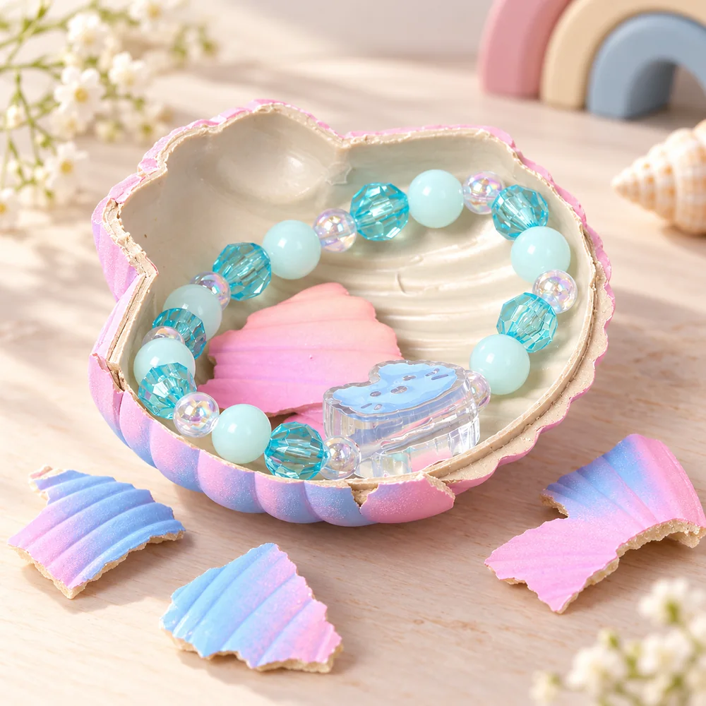 The shell broken open with a beaded bracelet inside — mint and turquoise beads with a clear charm, shell fragments scattered around