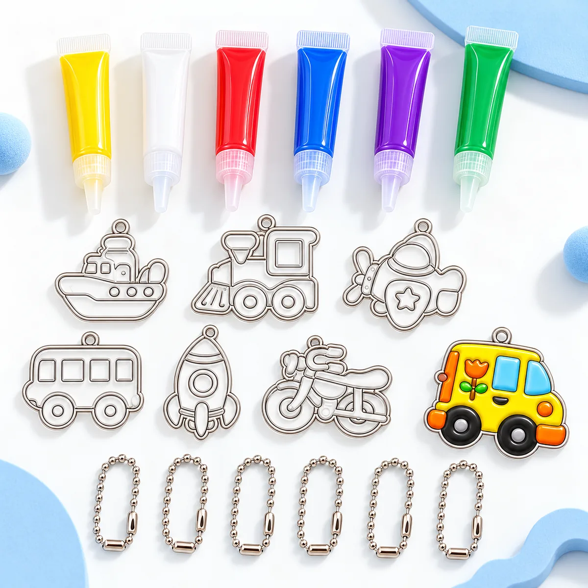The three Paint and Shine Keychain kits side by side - Space, Unicorn and Vehicles - with finished charms in front of each box