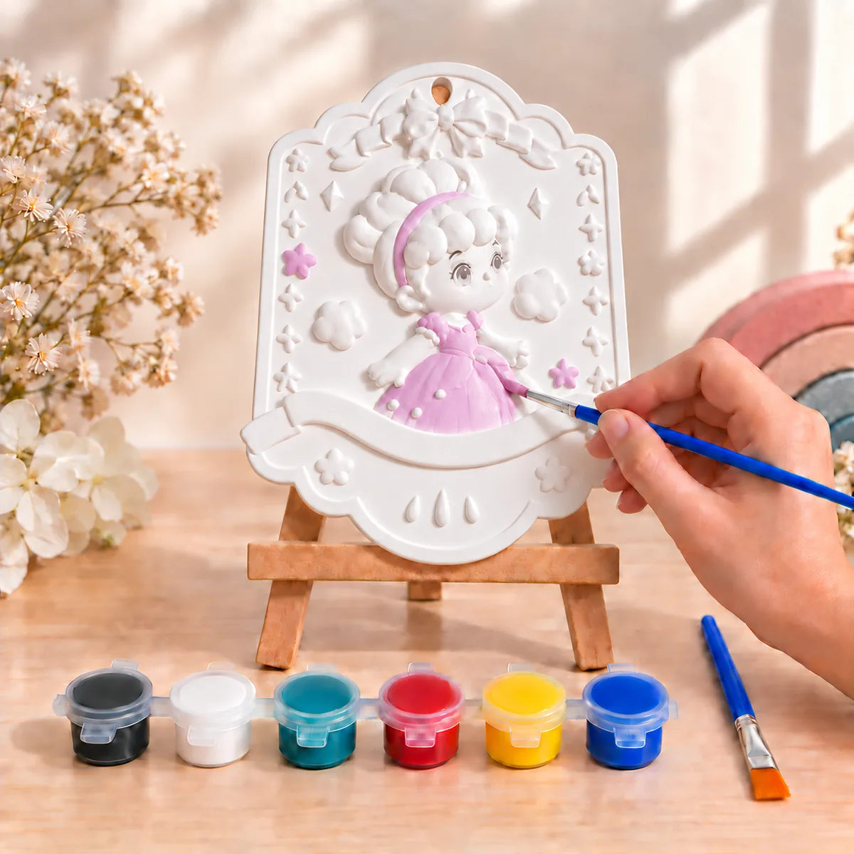 A princess plaque on a mini wooden easel, her full skirt painted lilac with pearl trim, surrounded by clouds, stars and small flowers, with a blank banner across the bottom for a name