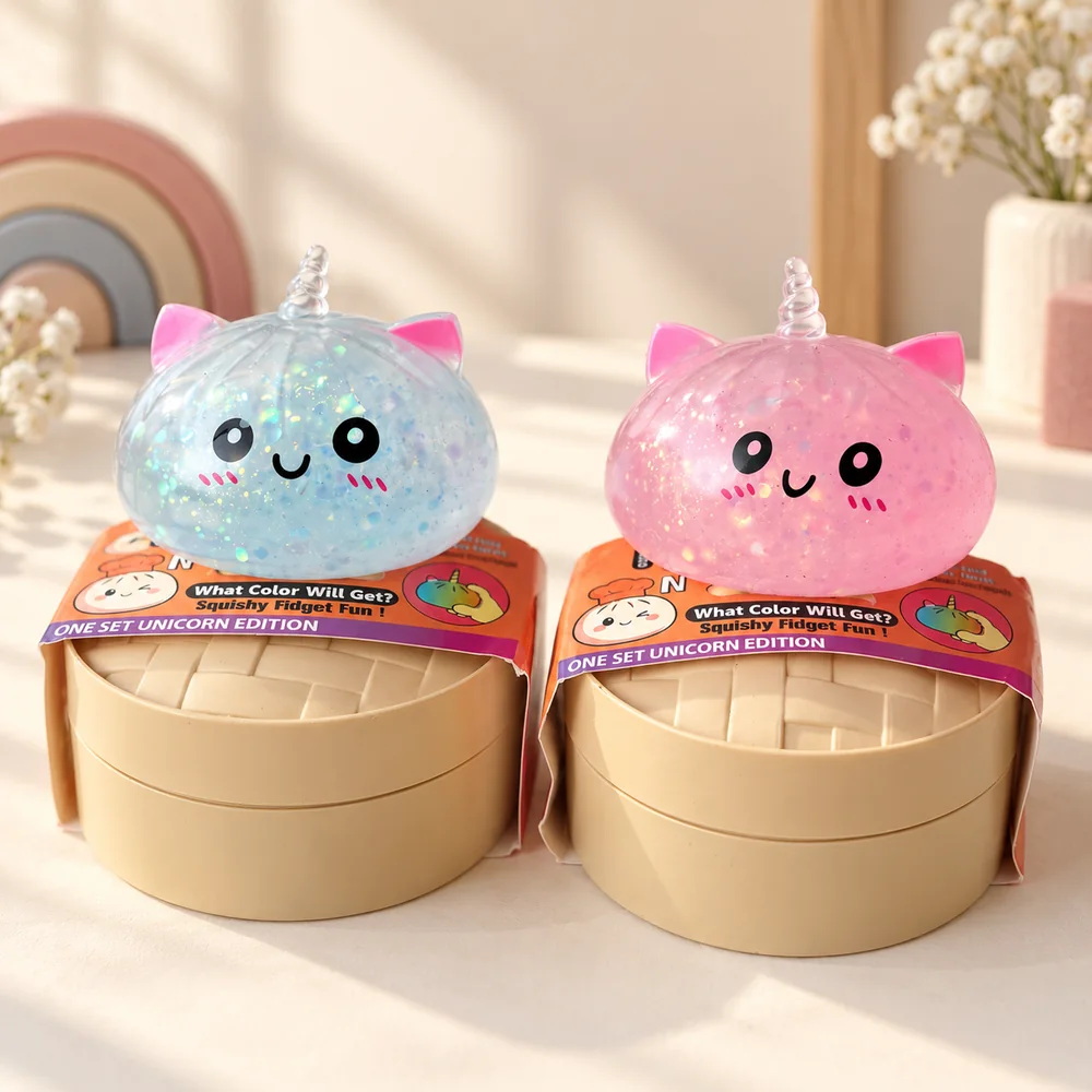 A blue and a pink unicorn bun squishy sitting on their steamer baskets, glitter suspended inside the clear gel