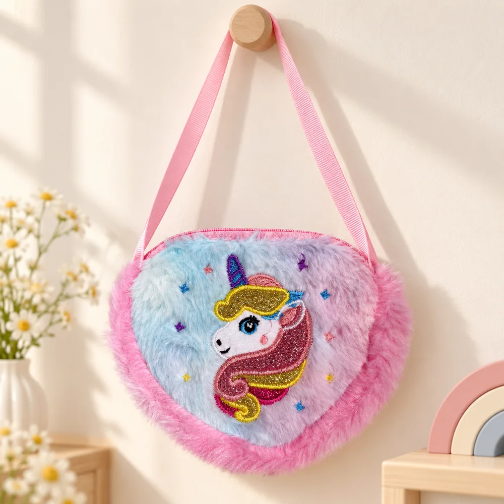 The unicorn bag hanging from a wooden peg by its pink ribbon strap, showing the heart shape and hot-pink fur trim